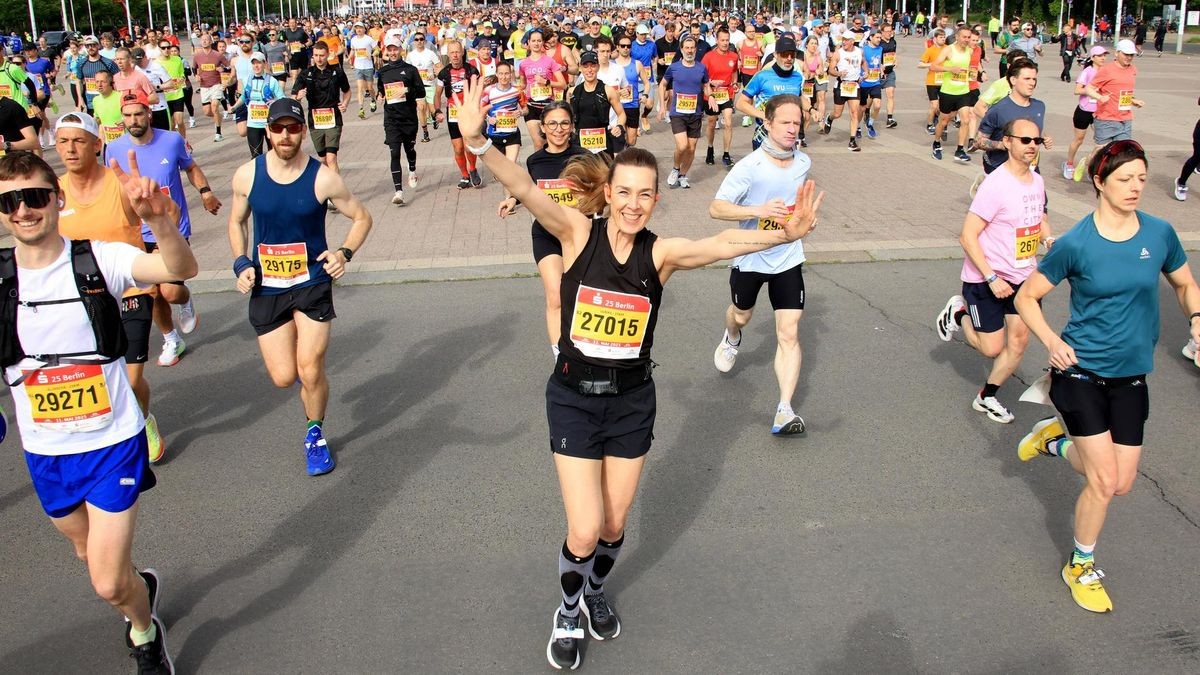 Das Olympiastadion Berlin im Sonnenschein, umgeben von begeisterten Zuschauern