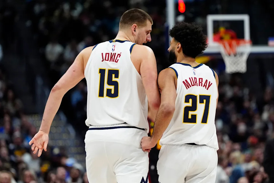 Denver Nuggets players strategizing on the court during an NBA game